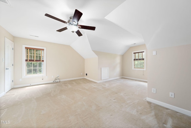 additional living space with ceiling fan, baseboards, light carpet, and vaulted ceiling