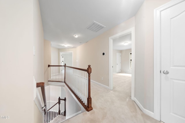 hall featuring an upstairs landing, carpet flooring, and baseboards