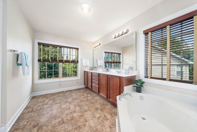 bathroom featuring a bath, double vanity, and baseboards