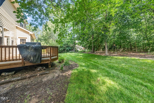 view of grassy yard featuring a wooden deck