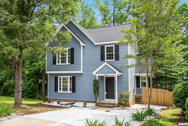 view of front of property featuring a shingled roof and fence