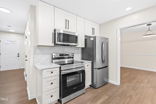 kitchen with stainless steel appliances, light wood-style flooring, white cabinets, baseboards, and recessed lighting