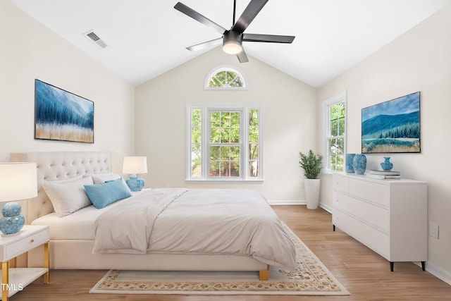 bedroom with light wood-style floors, lofted ceiling, baseboards, and a ceiling fan