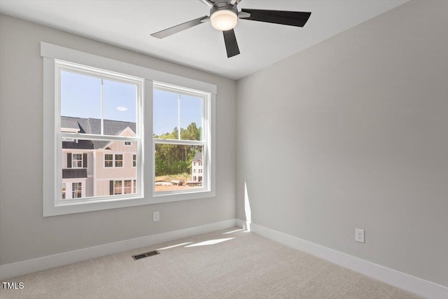 carpeted spare room with baseboards and ceiling fan