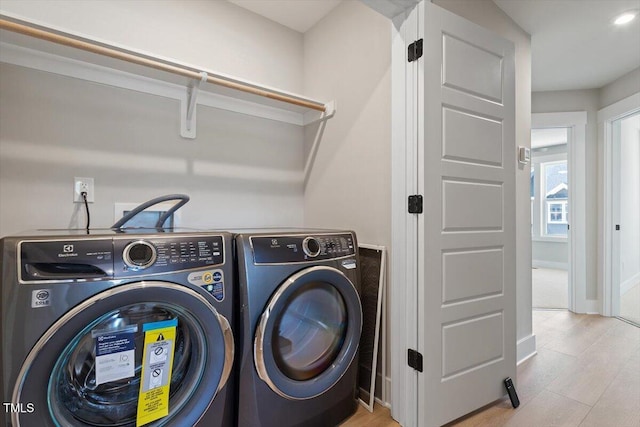 washroom with independent washer and dryer and baseboards