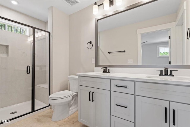 full bath featuring toilet, a shower stall, and double vanity