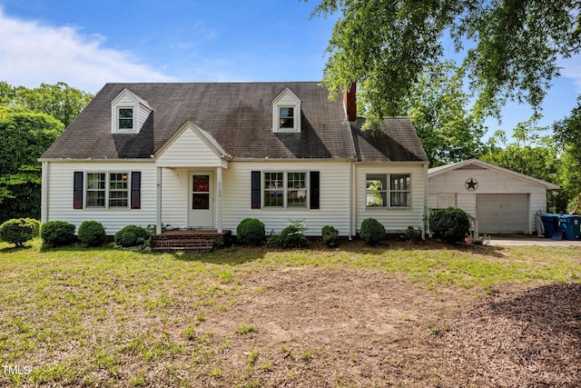 cape cod house with an outbuilding, a detached garage, and a front yard