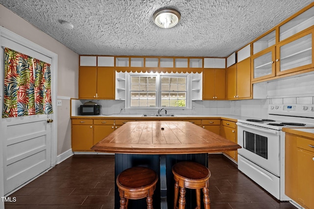 kitchen with white range with electric stovetop, a sink, open shelves, black microwave, and butcher block counters