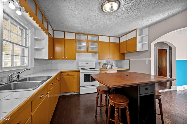 kitchen with white electric stove, a sink, open shelves, dark wood-type flooring, and a textured ceiling