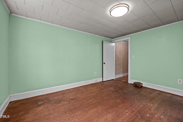 unfurnished room with ornamental molding, baseboards, and wood finished floors