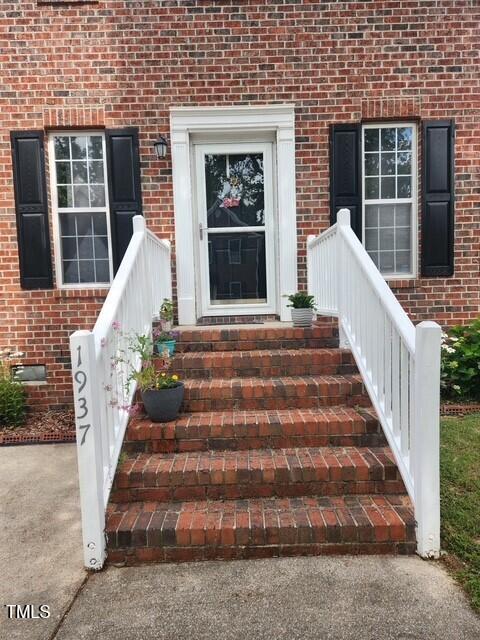 doorway to property with brick siding