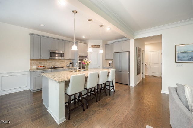 1201 Pleasant Falls Ct, Wake Forest, NC 27587 - kitchen featuring appliances with stainless steel finishes, gray cabinets, a kitchen bar, crown molding, and a center island with sink