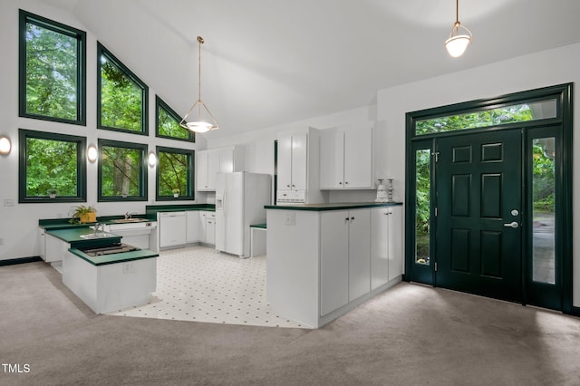 224 Crawford Rd, Hillsborough, NC 27278 - kitchen with a peninsula, white refrigerator with ice dispenser, dark countertops, white cabinetry, and high vaulted ceiling