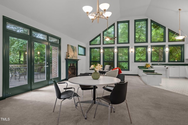 224 Crawford Rd, Hillsborough, NC 27278 - dining area with high vaulted ceiling, light carpet, a chandelier, and a glass covered fireplace