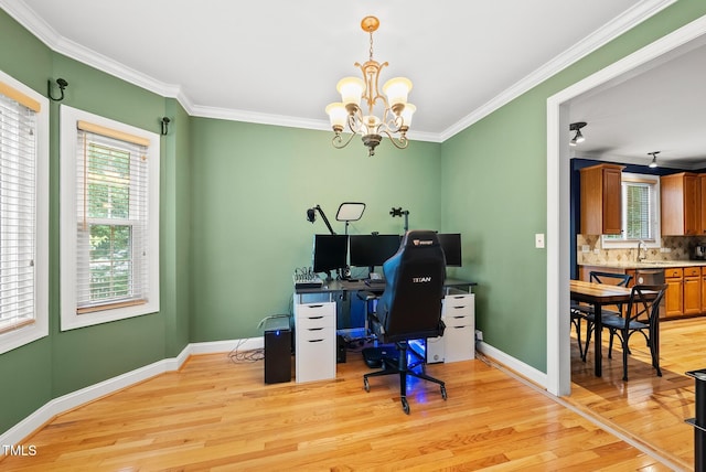 office with light wood finished floors, a chandelier, healthy amount of natural light, crown molding, and baseboards