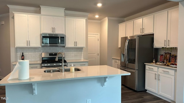 3112 Star Gazing Ln, Durham, NC 27703 - kitchen featuring appliances with stainless steel finishes, a sink, decorative backsplash, white cabinets, and a kitchen bar