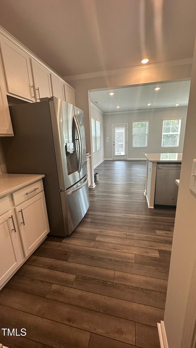 3112 Star Gazing Ln, Durham, NC 27703 - kitchen with appliances with stainless steel finishes, dark wood finished floors, ornamental molding, white cabinets, and plenty of natural light
