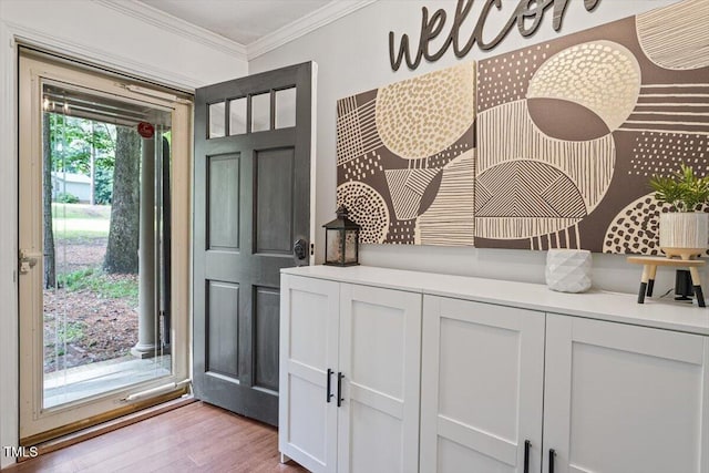 entrance foyer with crown molding and light wood-style floors