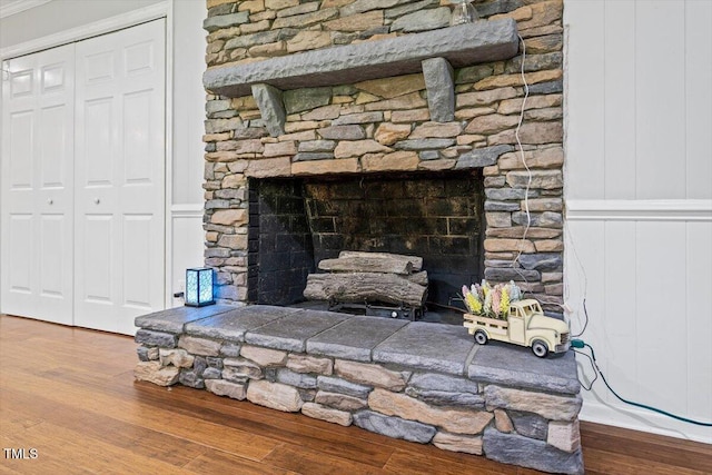 detailed view of a decorative wall, wood finished floors, and a fireplace