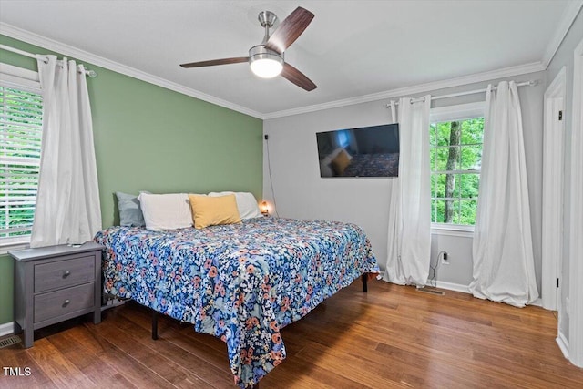 bedroom with crown molding, wood finished floors, a ceiling fan, and baseboards