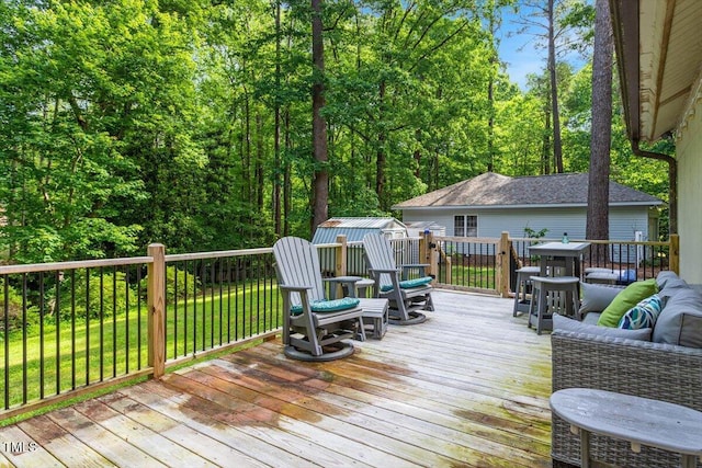 wooden deck featuring an outbuilding, a storage unit, and a yard