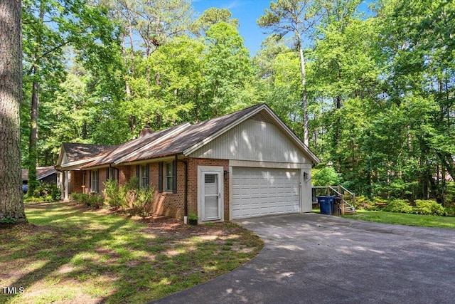 ranch-style house featuring brick siding, driveway, a garage, and a chimney