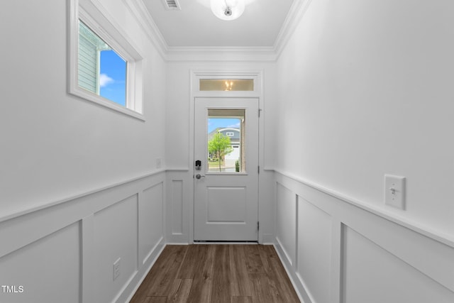 doorway with a decorative wall, crown molding, a wainscoted wall, and dark wood finished floors