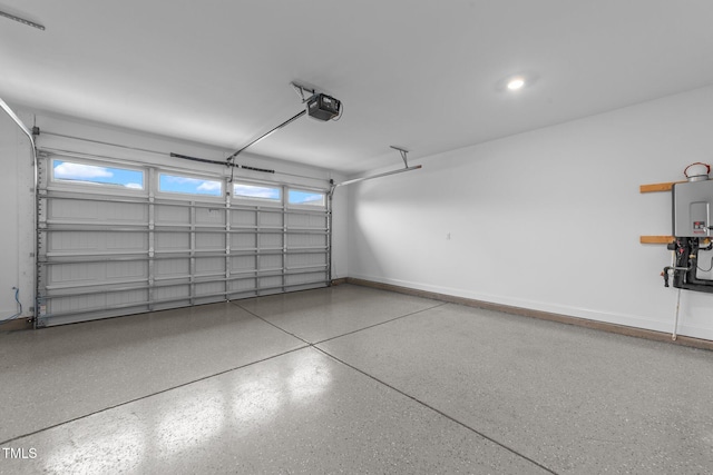 garage with a garage door opener, tankless water heater, and baseboards