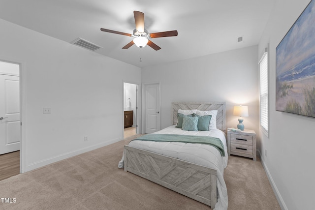bedroom with light carpet, baseboards, ensuite bathroom, and ceiling fan