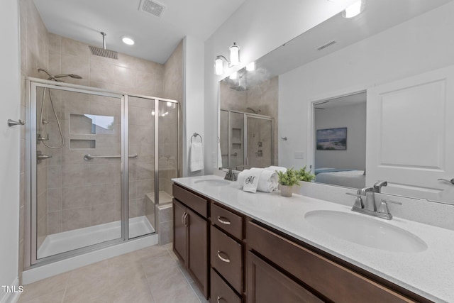 bathroom featuring tile patterned floors, a stall shower, double vanity, and ensuite bathroom