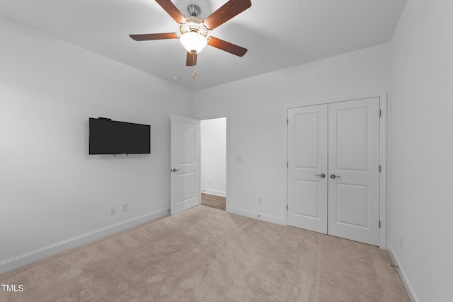 unfurnished bedroom with carpet flooring, baseboards, a closet, and ceiling fan