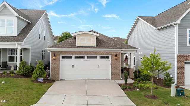 traditional-style home with brick siding, a front lawn, concrete driveway, roof with shingles, and an attached garage