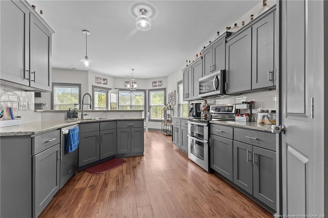 2677 Cypress Lakes Rd, Hope Mills, NC 28348 - kitchen featuring stainless steel appliances, gray cabinets, a sink, a peninsula, and decorative backsplash