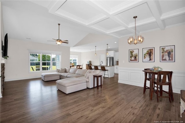 living room with dark wood-style flooring, beamed ceiling, a ceiling fan, a chandelier, and a wainscoted wall