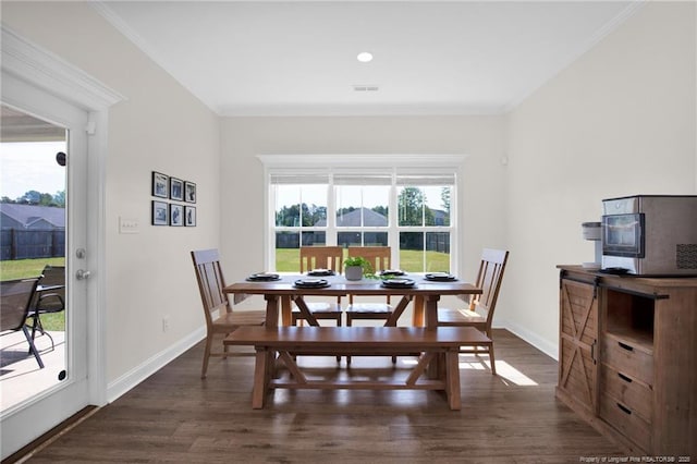 dining room featuring dark wood-style flooring, baseboards, and crown molding