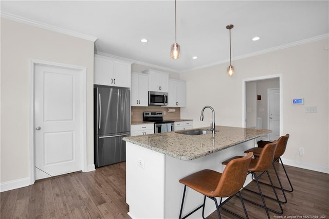 kitchen featuring a sink, stainless steel appliances, white cabinetry, a breakfast bar, and dark wood finished floors