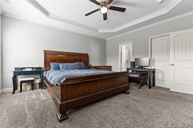 carpeted bedroom with a tray ceiling, ornamental molding, and ceiling fan