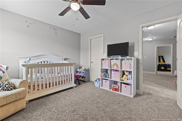 carpeted bedroom with a nursery area, baseboards, and ceiling fan