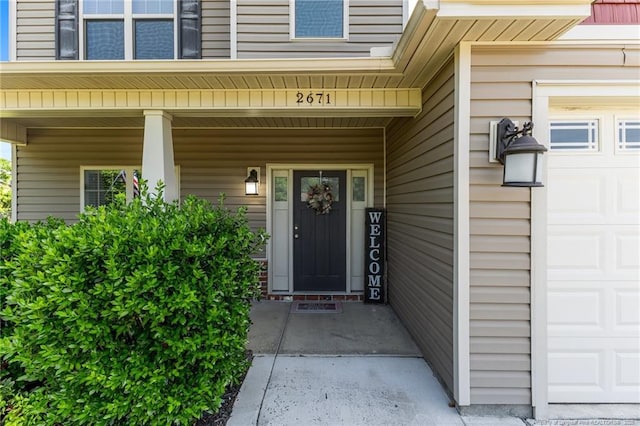 property entrance featuring a garage and covered porch