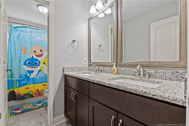 bathroom featuring double vanity, baseboards, toilet, and a shower with shower curtain