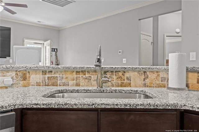 2671 Cypress Lakes Rd, Hope Mills, NC 28348 - kitchen featuring a sink, dark brown cabinets, ornamental molding, a ceiling fan, and light stone countertops