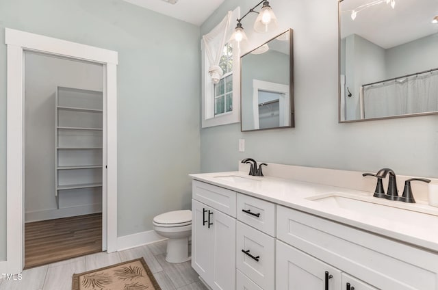 303 Godwin St, Selma, NC 27576 - bathroom with toilet, double vanity, baseboards, and wood finished floors