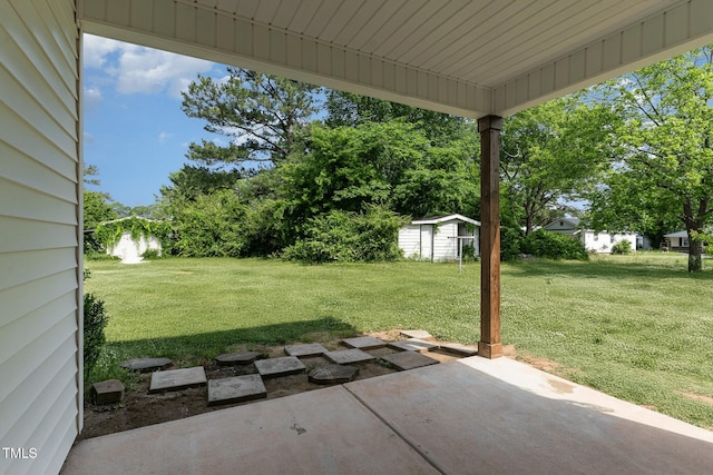 303 Godwin St, Selma, NC 27576 - view of green lawn with a patio area, a storage unit, and an outbuilding