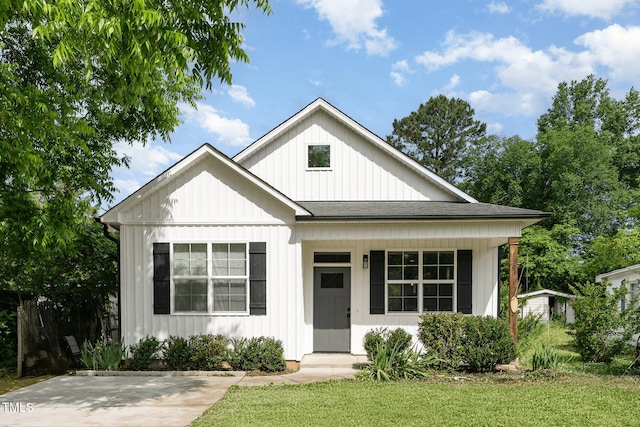 303 Godwin St, Selma, NC 27576 - view of front of property with board and batten siding, roof with shingles, a front lawn, and covered porch