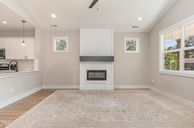 303 Godwin St, Selma, NC 27576 - unfurnished living room featuring plenty of natural light, a fireplace, recessed lighting, a ceiling fan, and baseboards
