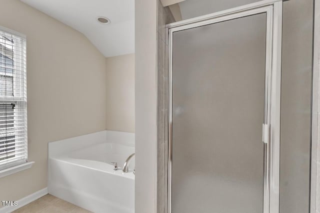full bathroom featuring a garden tub, vaulted ceiling, a stall shower, baseboards, and tile patterned flooring