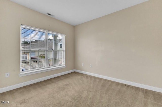 carpeted empty room featuring baseboards