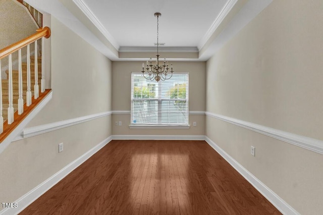 unfurnished dining area with wood finished floors, a chandelier, stairway, baseboards, and a raised ceiling