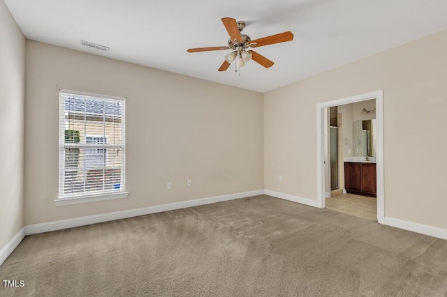 carpeted empty room featuring a ceiling fan and baseboards