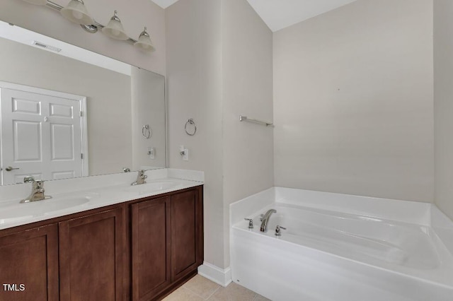 bathroom with a garden tub, tile patterned floors, double vanity, and baseboards